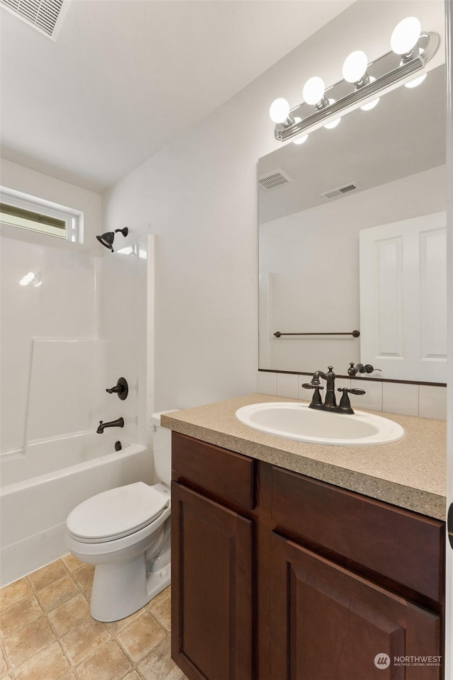 full bathroom featuring washtub / shower combination, vanity, and toilet