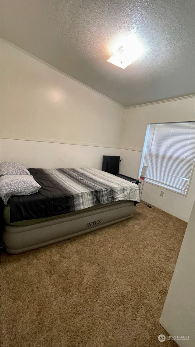 bedroom with carpet floors and a textured ceiling