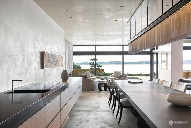 5505 Lake Washington Blvd NE Unit 1-D, Kirkland, WA 98033 - dining room with concrete flooring, a water view, and a wall of windows