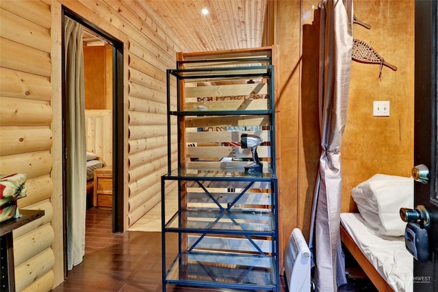 interior space featuring hardwood / wood-style floors, wooden ceiling, and log walls