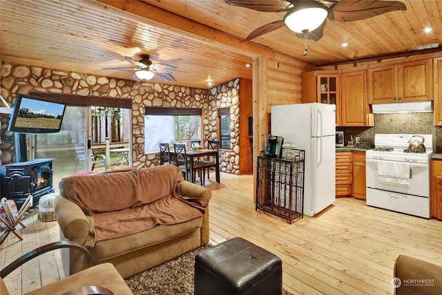 living room featuring light wood-type flooring, a wood stove, wood ceiling, and log walls