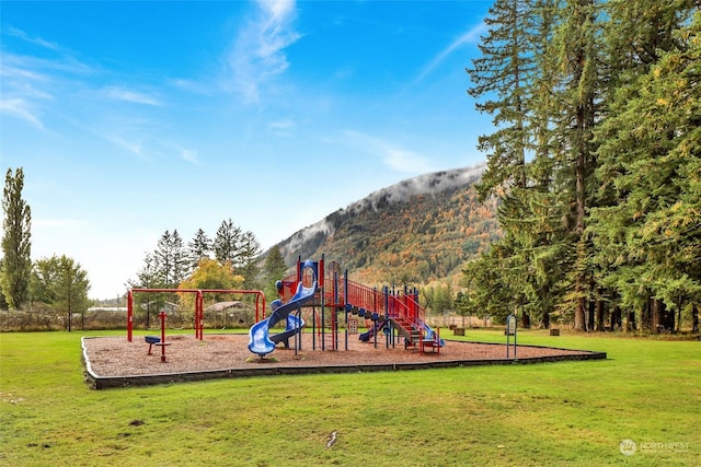 view of jungle gym featuring a mountain view and a yard