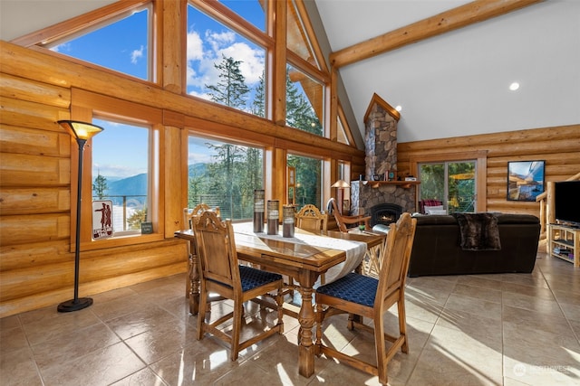 dining room featuring a mountain view, high vaulted ceiling, a fireplace, log walls, and beam ceiling