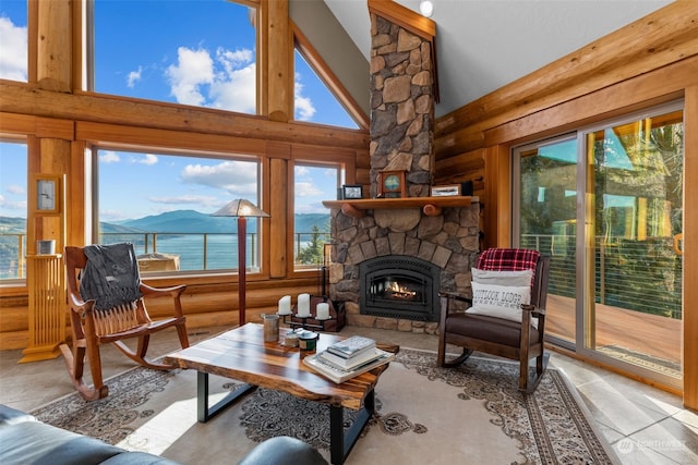 interior space with high vaulted ceiling, a water and mountain view, and a stone fireplace