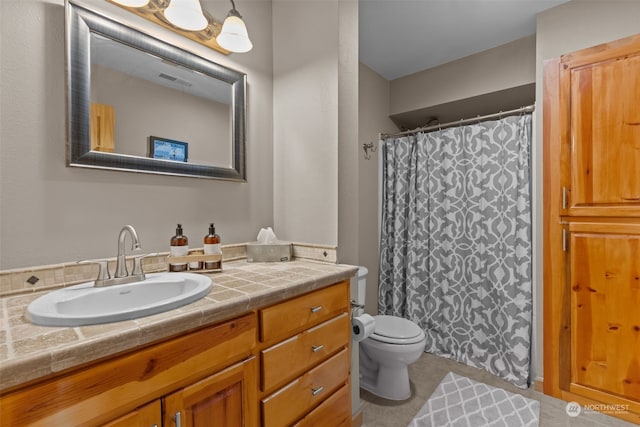 bathroom with tile patterned floors, vanity, and toilet