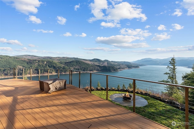 wooden terrace with grilling area and a water and mountain view