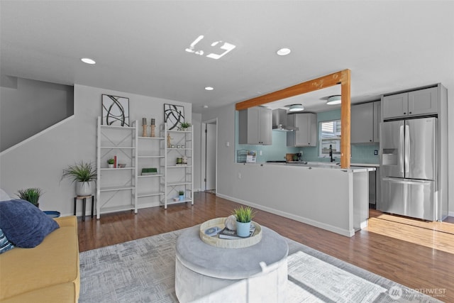 living area featuring baseboards, wood finished floors, and recessed lighting