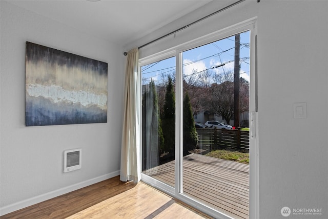 doorway to outside featuring wood finished floors, visible vents, and baseboards