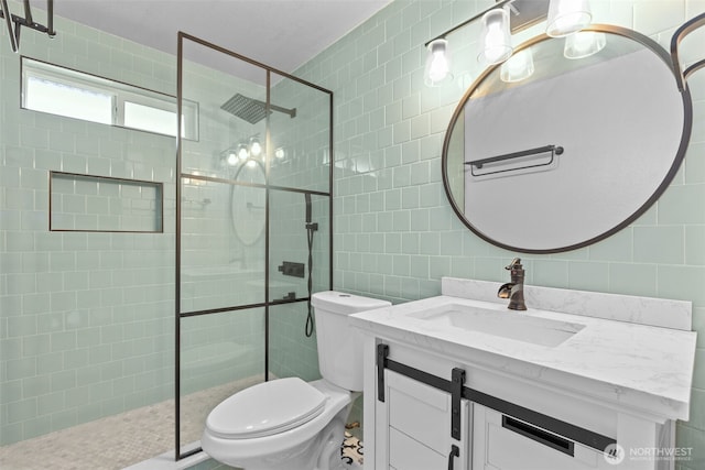 bathroom with vanity, tile walls, toilet, and walk in shower