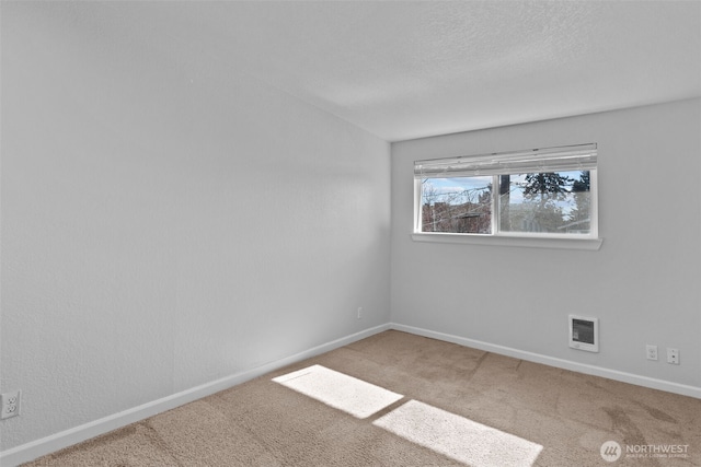 empty room featuring a textured ceiling, carpet, visible vents, and baseboards