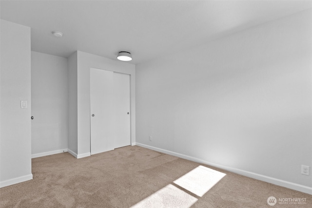 carpeted spare room with baseboards