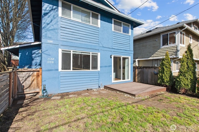 back of house featuring a lawn and fence