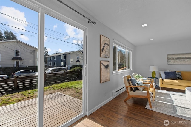 1128 N 91st St, Seattle, WA 98103 - living area with wood finished floors, a baseboard heating unit, recessed lighting, and baseboards