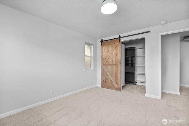 1128 N 91st St, Seattle, WA 98103 - unfurnished bedroom with carpet floors, baseboards, a barn door, and a closet