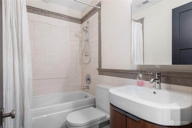 full bathroom featuring vanity, toilet, tile walls, and shower / bath combo with shower curtain