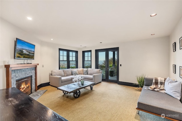 carpeted living room featuring a tile fireplace and french doors