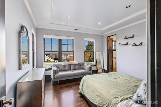 bedroom featuring dark hardwood / wood-style floors, crown molding, and a tray ceiling