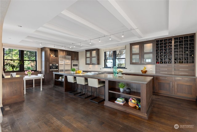 kitchen featuring a center island, white oven, rail lighting, built in refrigerator, and dark hardwood / wood-style floors