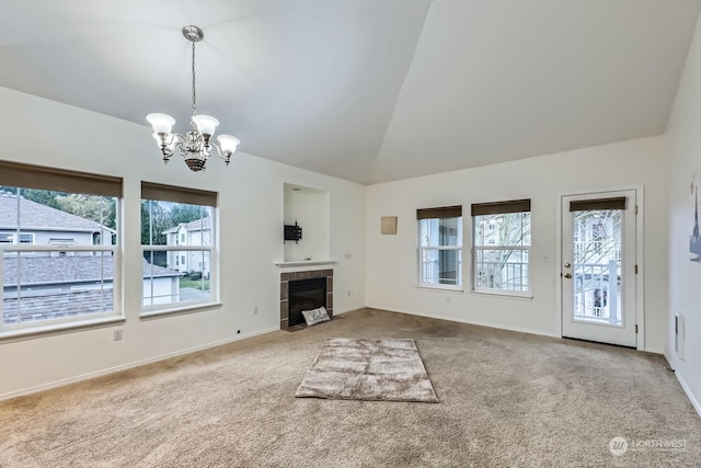 unfurnished living room with carpet flooring, lofted ceiling, a healthy amount of sunlight, and a tiled fireplace