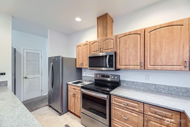 kitchen with light stone counters and appliances with stainless steel finishes