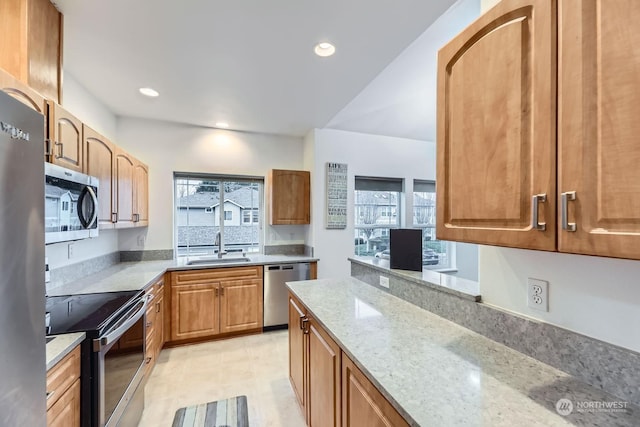 kitchen with sink, light stone countertops, and stainless steel appliances