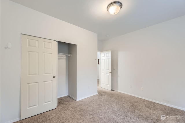 unfurnished bedroom featuring light colored carpet and a closet