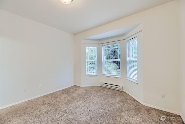 unfurnished room featuring baseboard heating and light carpet