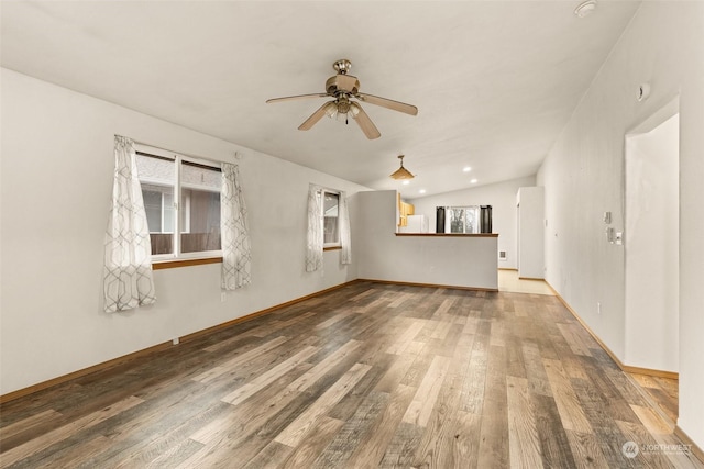 interior space featuring ceiling fan, wood-type flooring, and vaulted ceiling