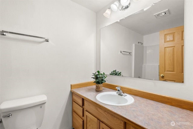 bathroom with vanity, toilet, and walk in shower