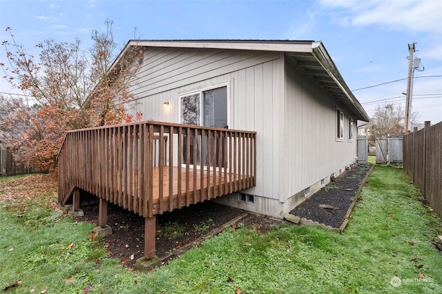 view of side of home with a yard and a wooden deck