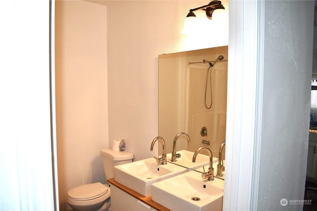 bathroom featuring toilet, walk in shower, and vanity