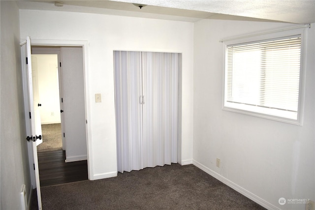 unfurnished bedroom featuring dark colored carpet