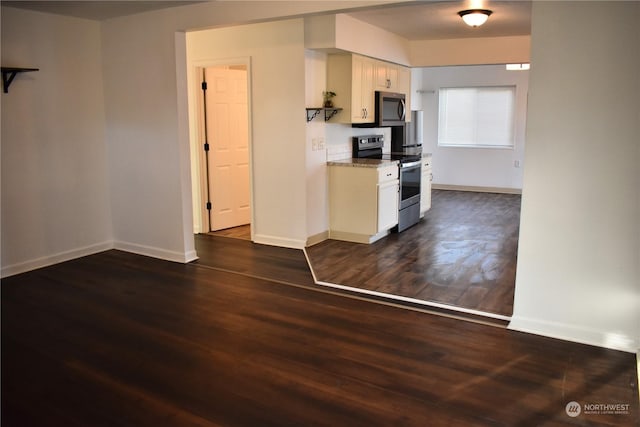 kitchen featuring white cabinets, stainless steel appliances, light stone countertops, and dark hardwood / wood-style flooring