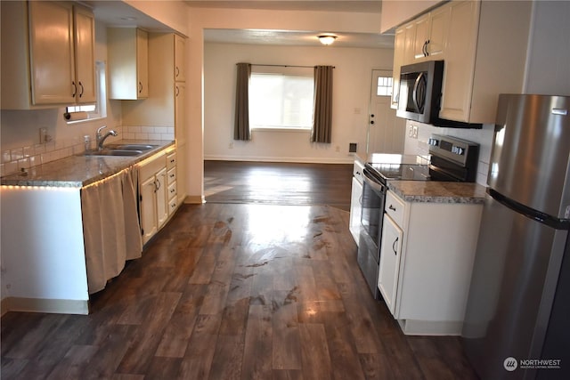 kitchen with sink, white cabinetry, appliances with stainless steel finishes, and dark hardwood / wood-style flooring