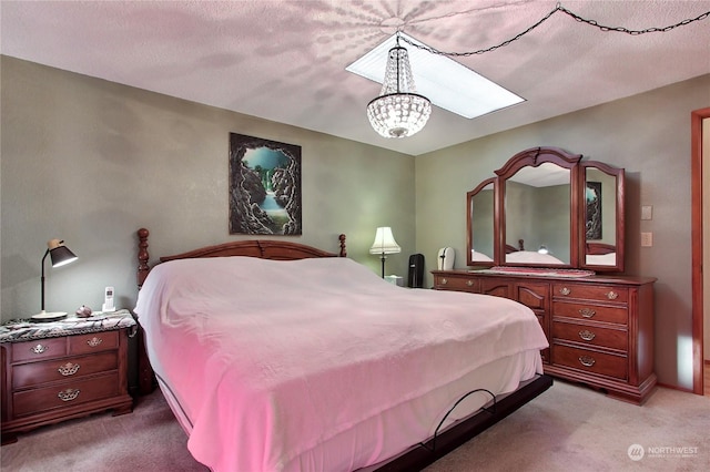 bedroom with light colored carpet, a textured ceiling, and an inviting chandelier