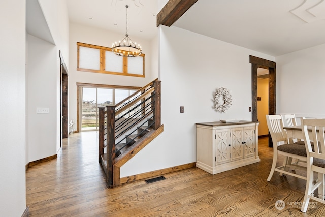 foyer with hardwood / wood-style flooring and a notable chandelier