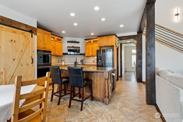 kitchen featuring a kitchen breakfast bar, light stone countertops, tasteful backsplash, a kitchen island, and stainless steel appliances