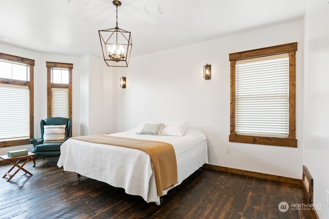 bedroom featuring dark wood-type flooring and a notable chandelier