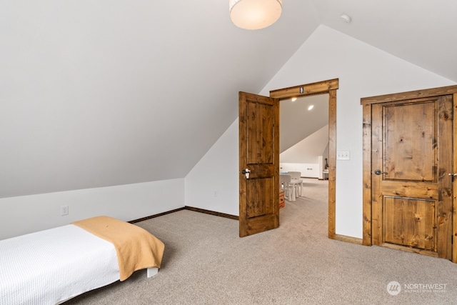 bedroom with light colored carpet and vaulted ceiling