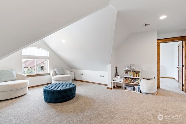 living area featuring carpet and vaulted ceiling