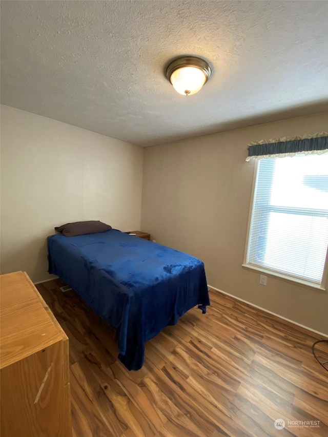 bedroom featuring dark hardwood / wood-style floors and a textured ceiling