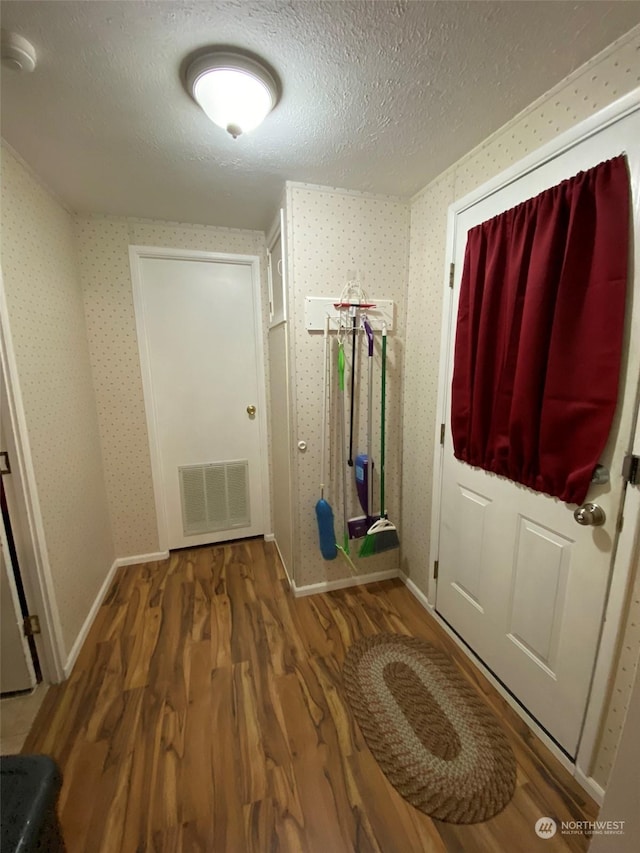 entryway with hardwood / wood-style flooring and a textured ceiling