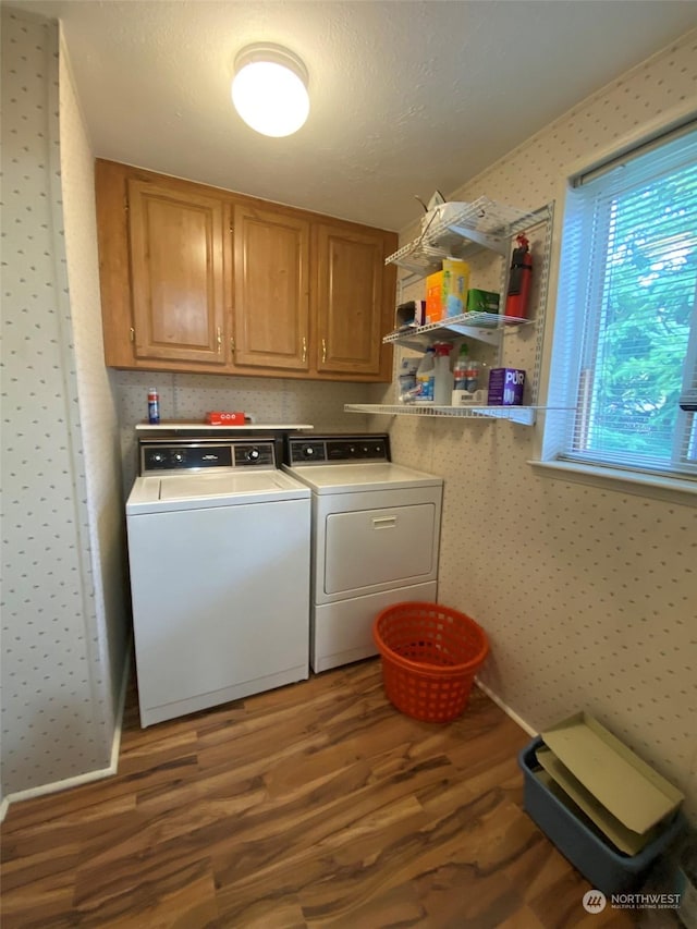 laundry area featuring cabinets, separate washer and dryer, hardwood / wood-style floors, and a textured ceiling