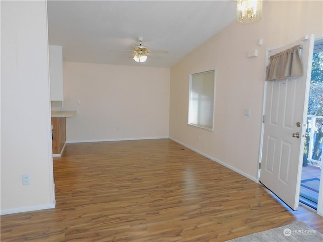 entryway featuring wood-type flooring, vaulted ceiling, and ceiling fan with notable chandelier