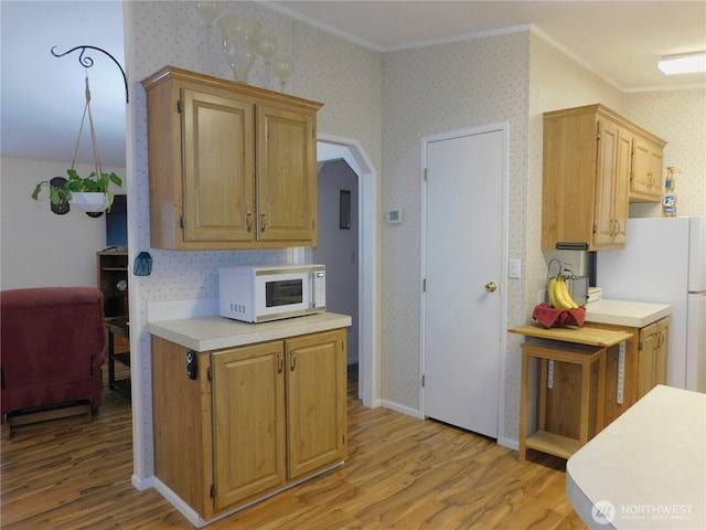 kitchen featuring crown molding, white appliances, and light hardwood / wood-style flooring