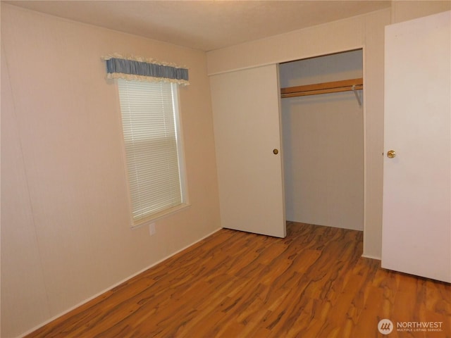 unfurnished bedroom featuring hardwood / wood-style floors and a closet