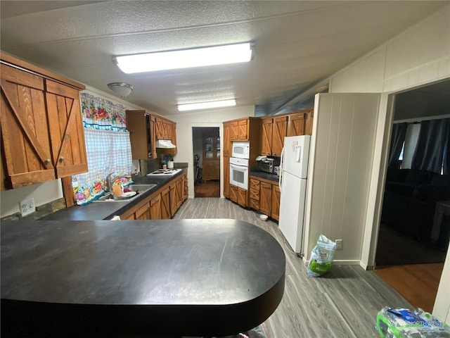 kitchen featuring white appliances, light hardwood / wood-style floors, and sink