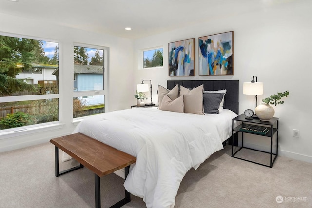 bedroom featuring light colored carpet and multiple windows