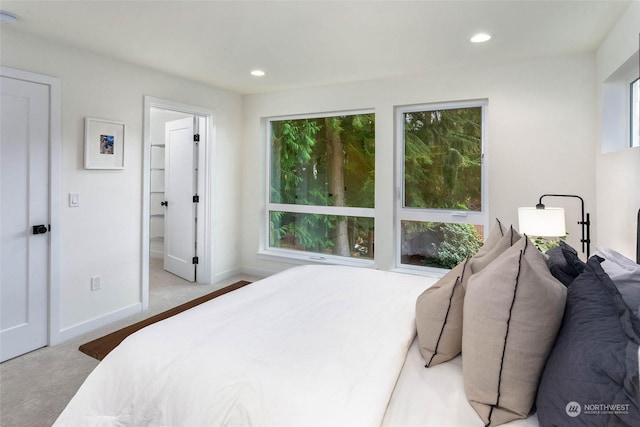 bedroom with light colored carpet and ensuite bath