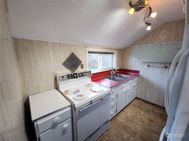 kitchen with lofted ceiling, refrigerator, sink, range with electric cooktop, and wooden walls